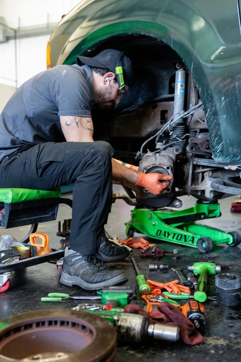Phoenix Auto Repair technician replacing brake pads and rotors with the wheel removed